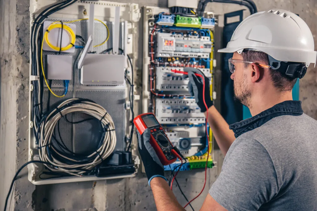 Electrician working on a switchboard with fuses